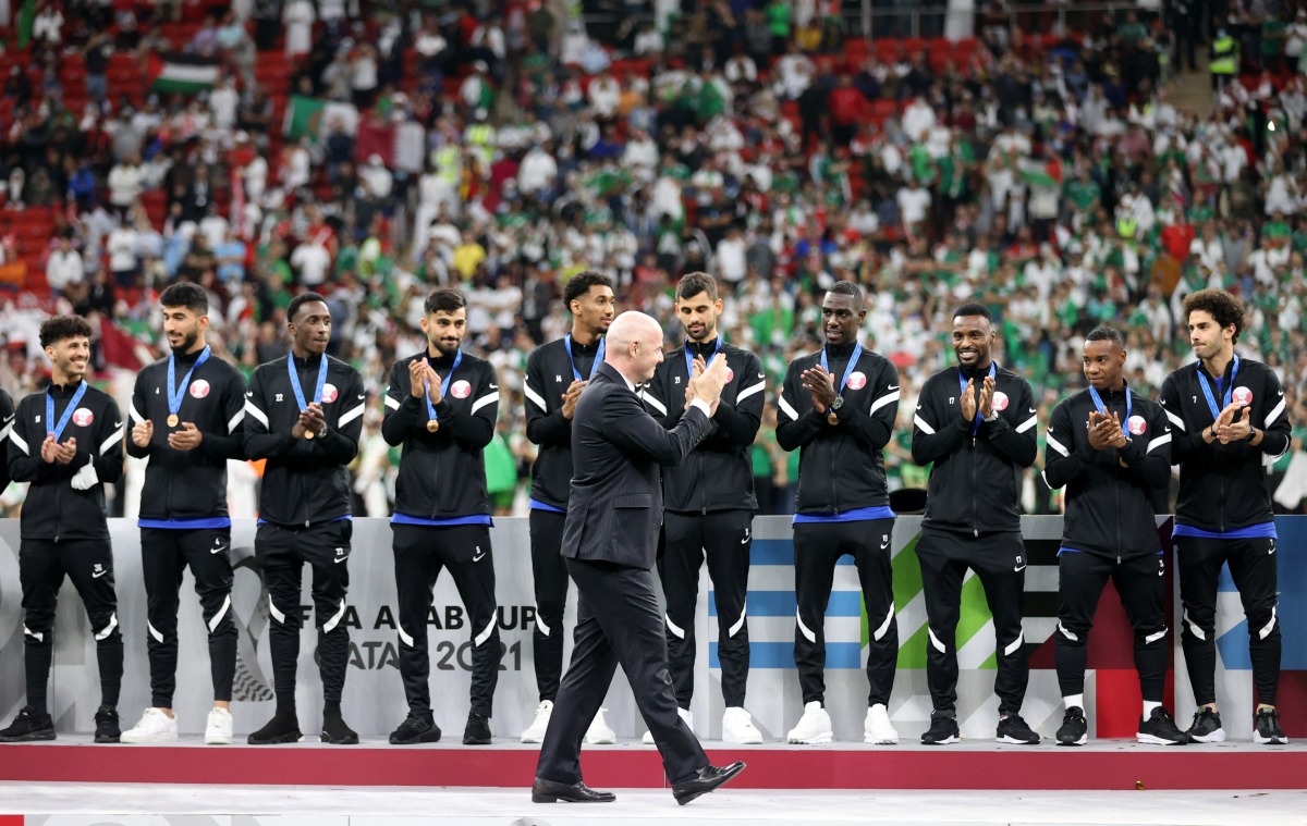 FIFA President Gianni Infantino applauds the Qatar players as they are presented with their third place medals.
