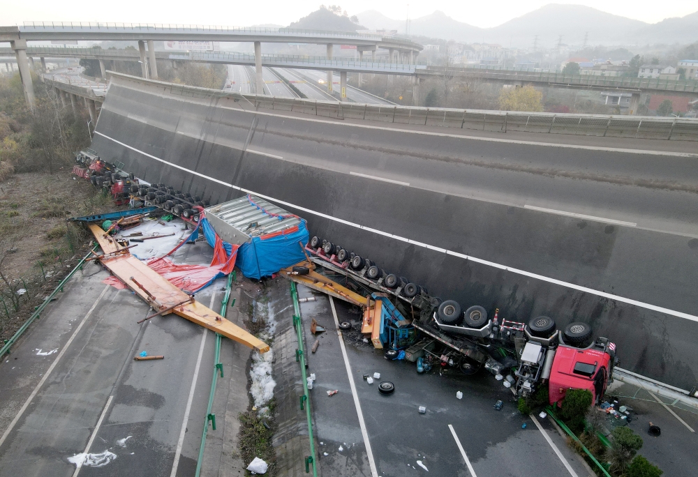 Overturned vehicles are seen at the site where a highway flyover collapsed in Ezhou, Hubei province, China December 19, 2021. Picture taken with a drone. REUTERS.