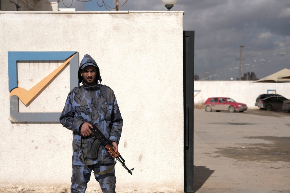 FILE PHOTO: A security officer stands in front of the High National Election Commission building in Benghazi, Libya December 16, 2021. REUTERS/Esam Omran Al-Fetori