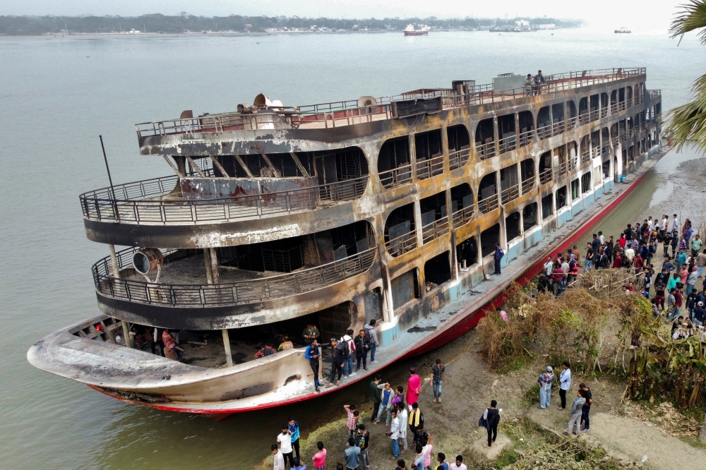 The burnt passenger ferry is seen anchored on the bank of Sugandha River which caught on a fire that killed several dozens in Jhalalathi, Bangladesh, December 24, 2021. REUTERS/Stringer