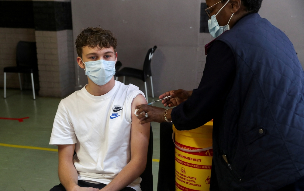 A healthcare worker administers a dose of the Pfizer coronavirus disease (COVID-19) vaccine to a teenager, amidst the spread of the SARS-CoV-2 variant Omicron, in Johannesburg, South Africa, December 9, 2021. REUTERS/ Sumaya Hisham/File Photo