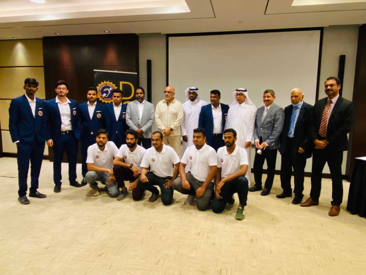 Officials and Qatar deaf cricket team players pose for a photograph following a press conference held in Doha.