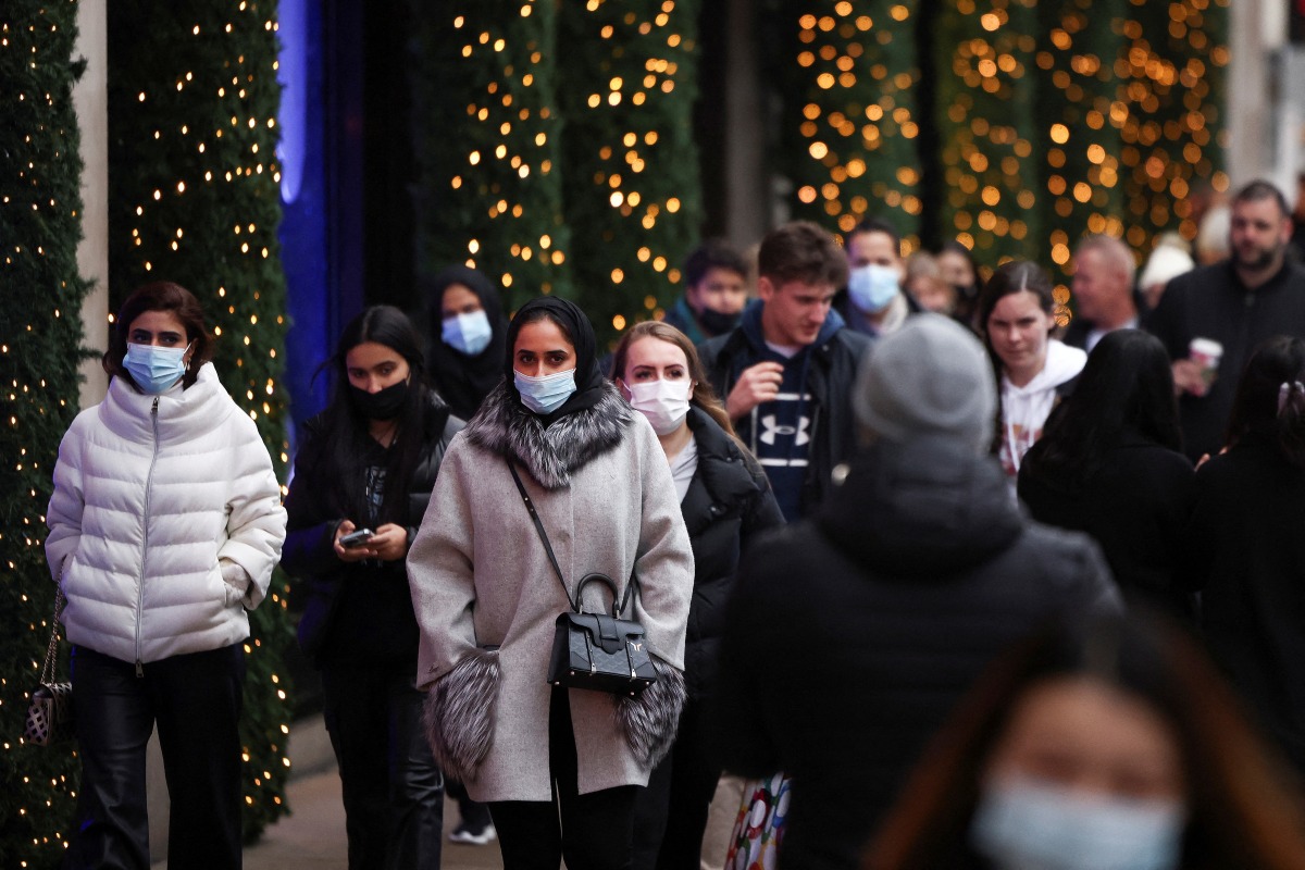FILE PHOTO: Shoppers walk along Oxford Street, amid the coronavirus disease (COVID-19) outbreak in LONDON, Britain, December 23, 2021. REUTERS/Henry Nicholls/File Photo

