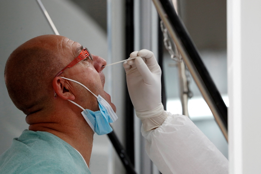 A man is tested as a mandatory measure for arriving passengers to prevent the spread of the coronavirus disease (COVID-19) at the international airport in Phuket, Thailand November 29, 2021. REUTERS/Jorge Silva/File Photo