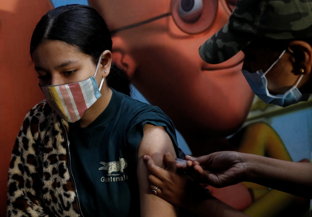 A girl receives a dose of the COVAXIN coronavirus disease (COVID-19) vaccine manufactured by Bharat Biotech, during a vaccination drive for children aged 15-18 in New Delhi, India, January 3, 2022. REUTERS/Adnan Abidi