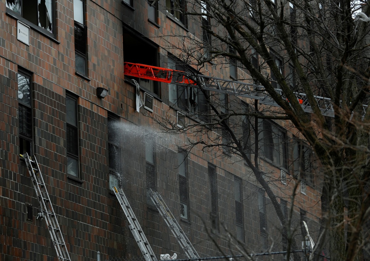 Emergency personnel from the FDNY respond to an apartment building fire in the Bronx borough of New York City, U.S., January 9, 2022. REUTERS/Lloyd Mitchell
