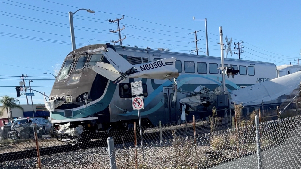 A train hits an aircraft that crashed on railway tracks in Los Angeles, California, U.S. January 9, 2022 in this screen grab from a social media video obtained by Reuters. Luis Jimenez/via REUTERS