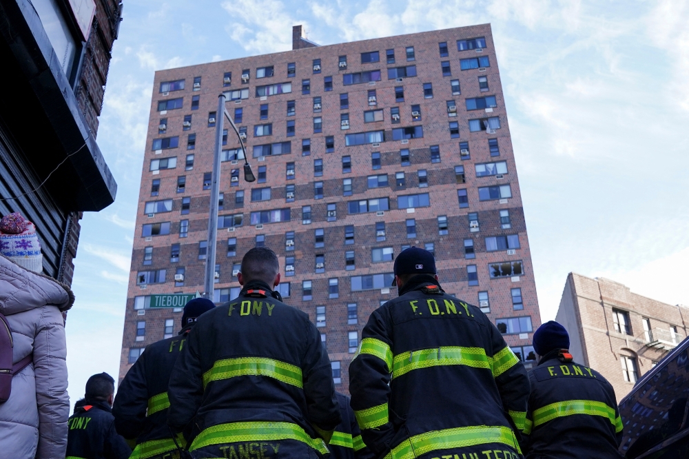 :Firefighters watch a news conference at a multi level apartment building following a fire, in the Bronx borough of New York City, New York, U.S. January 10, 2022. REUTERS/Carlo Allegri
