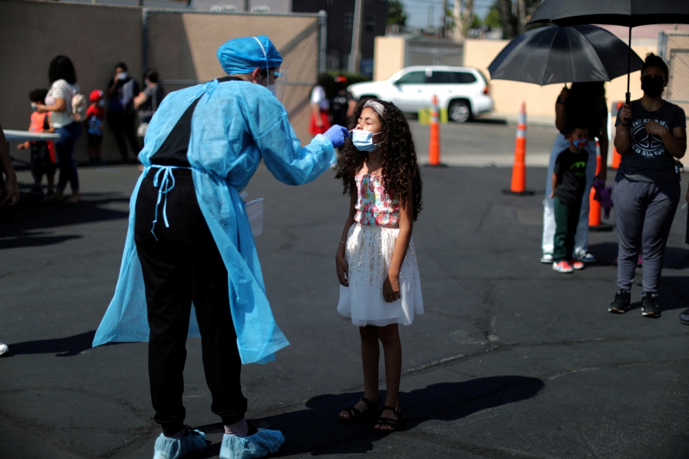 Alisson Argueta, 8, is given a coronavirus disease (COVID-19) test at a back-to-school clinic in South Gate, Los Angeles, California, U.S., August 12, 2021. REUTERS/Lucy Nicholson/File Photo