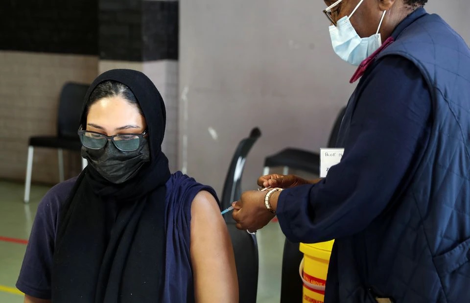 A healthcare worker administers the coronavirus disease (COVID-19) vaccine to a pregnant woman, amidst the spread of the SARS-CoV-2 variant Omicron, in Johannesburg, South Africa, December 9, 2021. REUTERS/ Sumaya Hisham