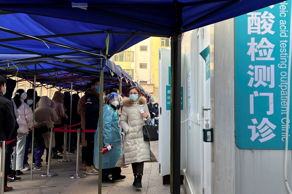 People line up to take nucleic acid tests at a testing site outside a hospital, following a new confirmed case of the coronavirus disease (COVID-19), in Beijing, China January 16, 2022. REUTERS/Yew Lun Tian