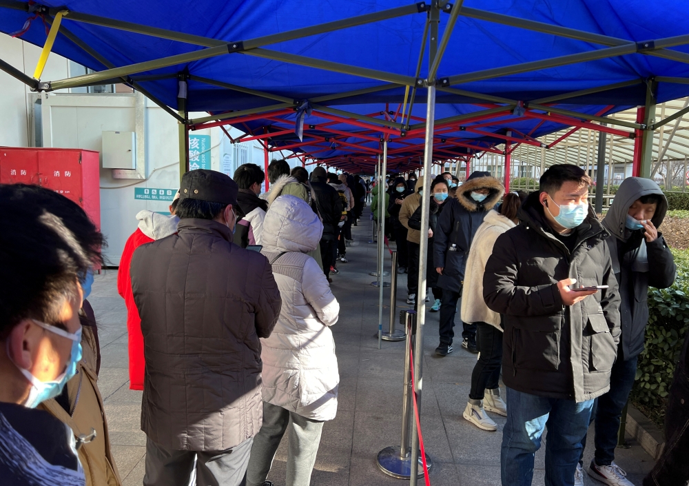 People line up to take nucleic acid tests at a testing site outside a hospital, following a new confirmed case of the coronavirus disease (COVID-19), in Beijing, China January 16, 2022. REUTERS/Yew Lun Tian