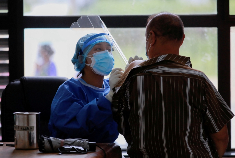 File photo of a health worker speaks to a man as she gives a dose of the Chinese Sinopharma vaccine against the coronavirus disease (Covid-19) in Kathmandu, Nepal, July 6, 2021. Reuters/Navesh Chitrakar/File Photo
