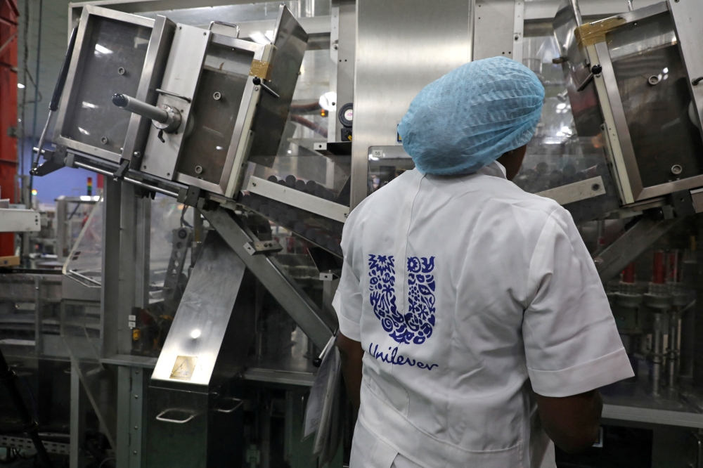 A woman stands behind a machine that is part of a toothpaste manufacturing line at the Unilever factory in Lagos, Nigeria January 18, 2018. Picture taken January 18, 2018. REUTERS/Afolabi Sotunde/File Photo