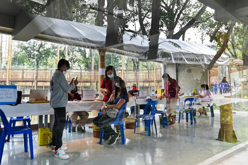 A woman receives a booster shot of Pfizer coronavirus disease (COVID-19) vaccine, at Manila Zoo, in Manila, Philippines, January 19, 2022. REUTERS/Lisa Marie David