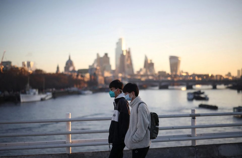 People wearing protective face masks walk over Waterloo Bridge during morning rush hour, amid the ongoing coronavirus disease (COVID-19) pandemic in London, Britain, January 21, 2022. REUTERS/Henry Nicholls


