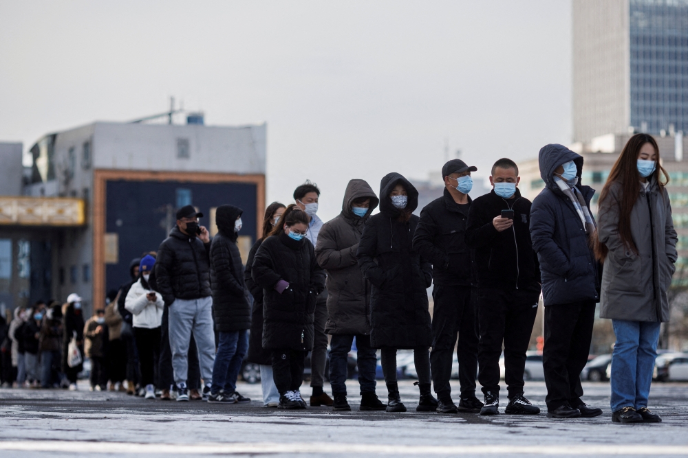 People line up to get a throat swab test at a temporary COVID-19 testing center as the coronavirus disease (COVID-19) continues in Beijing, China, January 26, 2022. REUTERS/Thomas Peter/File Photo