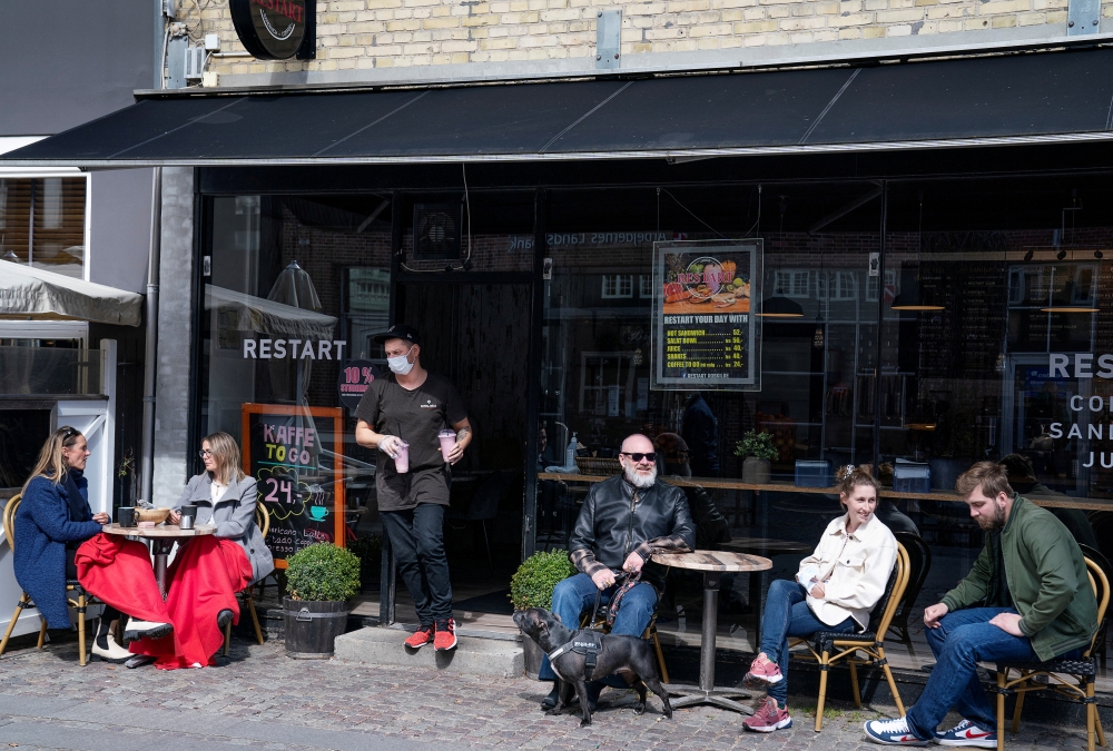 File photo: People enjoy outdoor service as cafes and restaurants reopen due to COVID-19 restrictions easing in Roskilde, Denmark April 21, 2021. Claus Bech/Ritzau Scanpix/via Reuters
