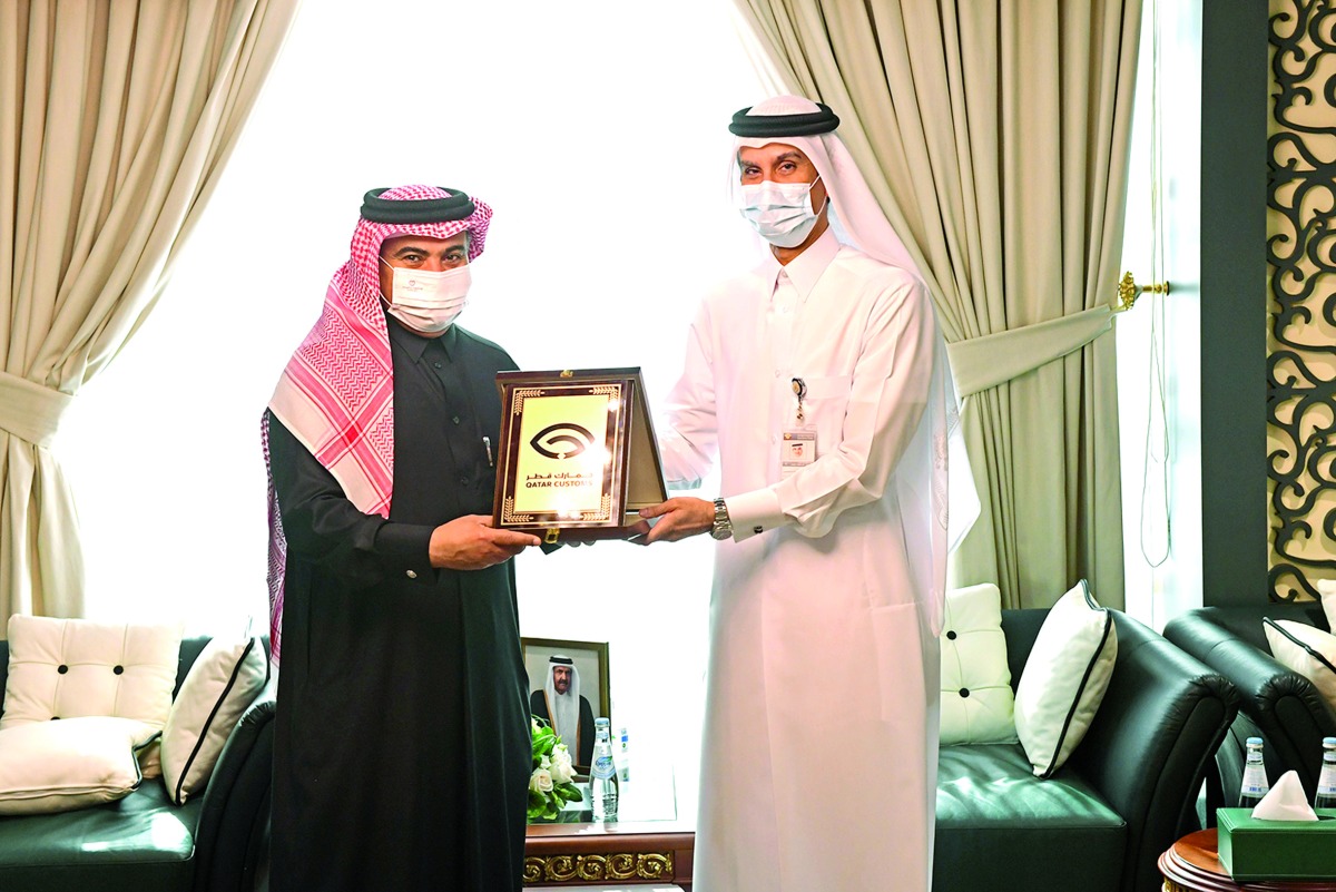 Minister of Finance H E Ali bin Ahmed Al Kuwari receiving the new logo from Chairman of the General Authority of Customs H E Ahmed bin Abdullah Al Jamal.