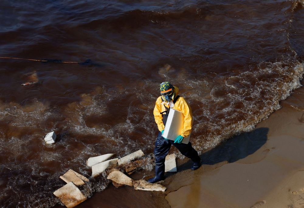 A worker cleans oil spills caused by a leak from an undersea pipeline 20 km (12.4 miles) off Thailand's eastern coast at Mae Ramphueng beach in Rayong province, Thailand, January 29, 2022. Reuters/Soe Zeya Tun