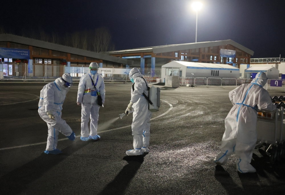 Staff wearing PPE sprays disinfectant ahead of the Beijing 2022 Winter Olympics in Zhangjiakou, China. February 1, 2022. REUTERS/Wolfgang Rattay