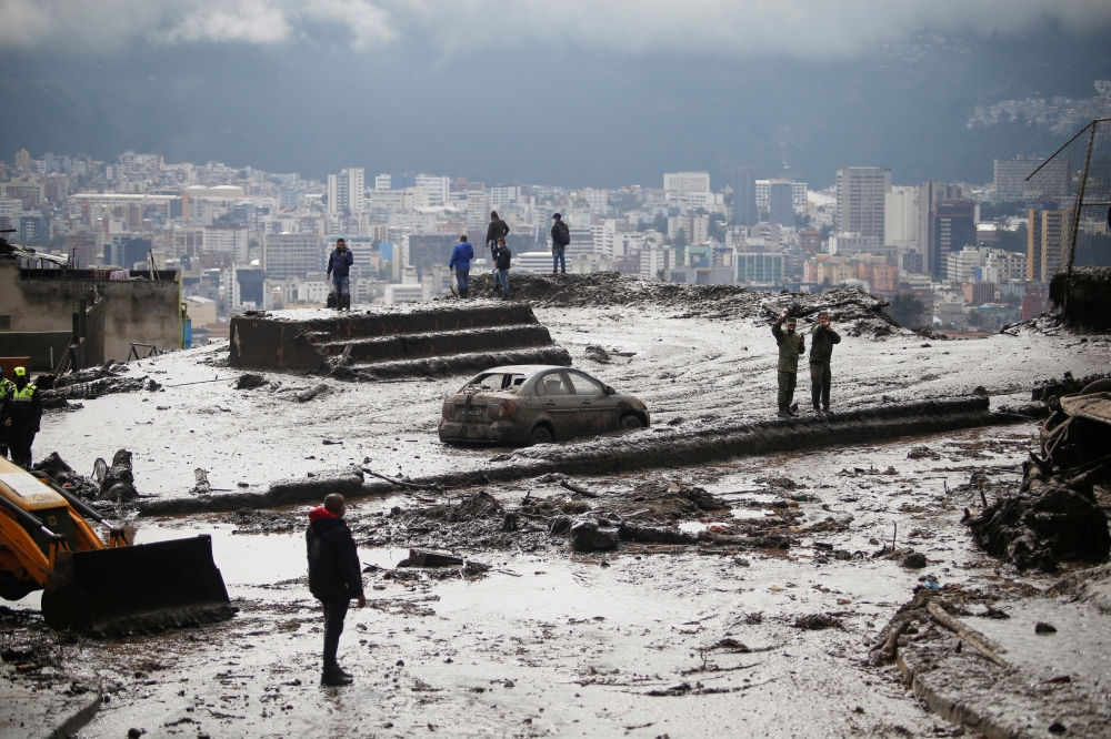 Residents are seen in an area of a landslide as firefighter rescue crews continue searching homes and streets covered by mud in Quito, Ecuador, February 1, 2022. REUTERS/Jonatan Rosas NO RESALES. NO ARCHIVES.
