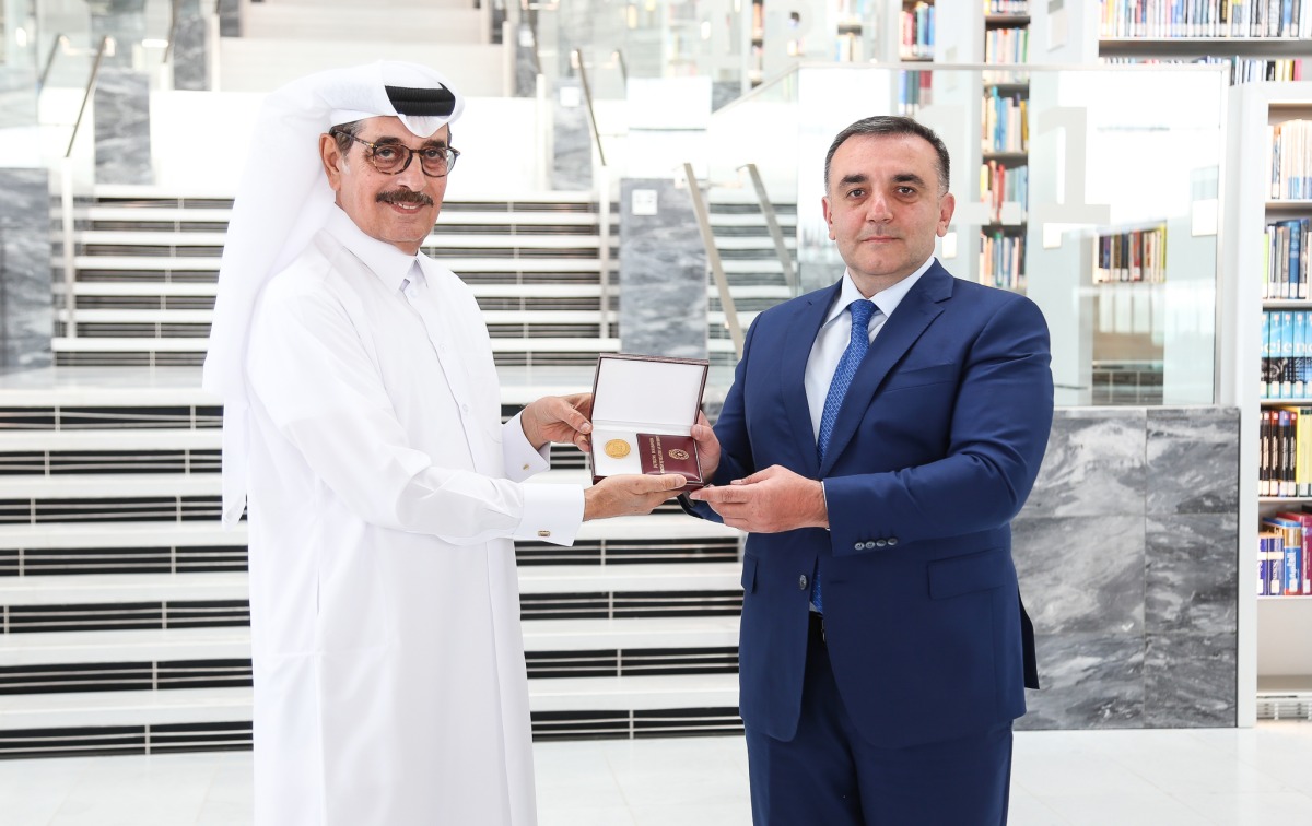 Minister of State and President of Qatar National Library H E Dr. Hamad bin Abdulaziz Al Kawari receiving the commemorative badge from Ambassador of Azerbaijan to Qatar Rashad Ismayilov.