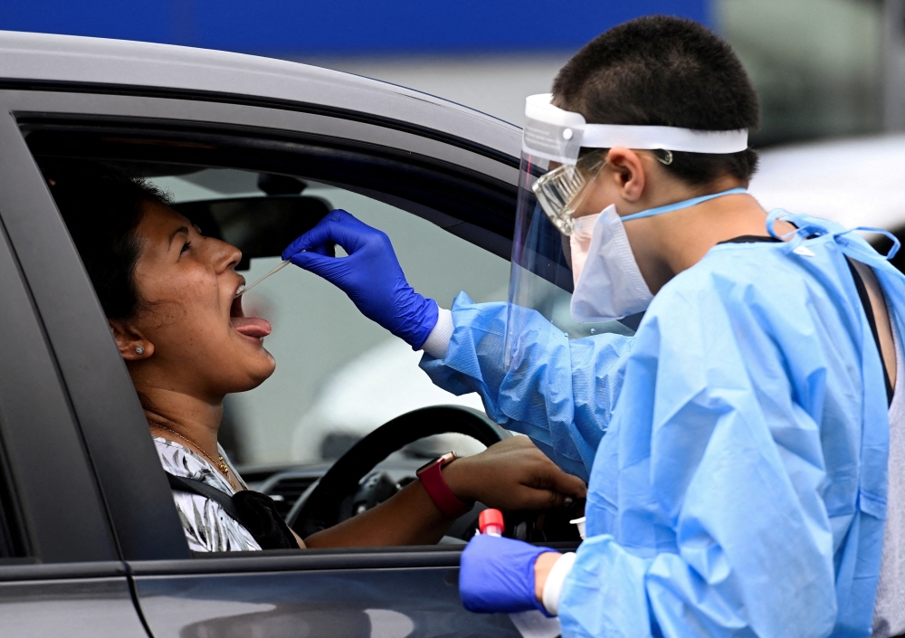 A woman takes a test for the coronavirus disease (COVID-19) at a testing centre in Sydney, Australia, January 5, 2022. REUTERS/Jaimi Joy/File Photo