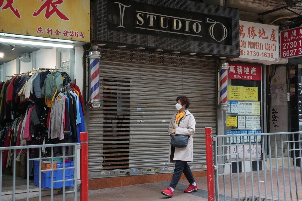 A pedestrian walks past a closed hair salon at a shopping mall, following the coronavirus disease (COVID-19) outbreak, in Hong Kong, China February 10, 2022. REUTERS/Lam Yik