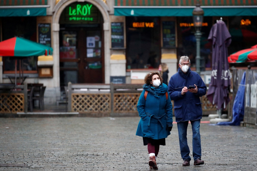 People wearing protective face masks walk at the Grand Place in Brussels, amid the rise of the coronavirus disease (COVID-19) cases due to the Omicron variant in Belgium, January 21, 2022. REUTERS/ Johanna Geron/File Photo