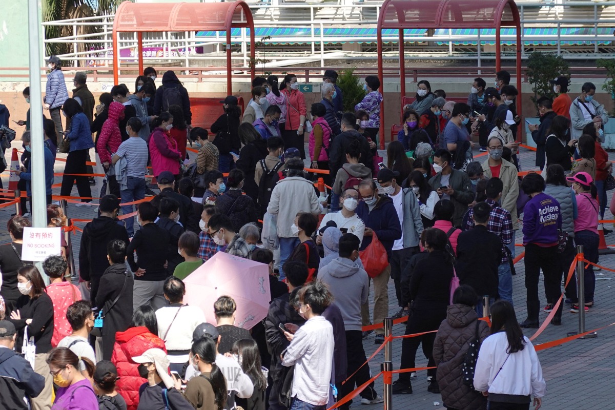 FILE PHOTO: People line up at a makeshift testing site for the coronavirus disease (COVID-19) following the outbreak, in HONG KONG, China February 11, 2022. REUTERS/Joyce Zhou/File Photo
