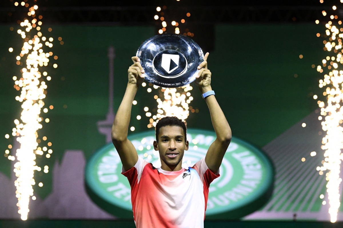 Canada's Felix Auger-Aliassime poses with the trophy as he celebrates after winning the final against Greece's Stefanos Tsitsipas REUTERS/Piroschka Van De Wouw
