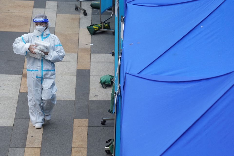 A medical worker walks past a makeshift testing centre for the coronavirus disease (COVID-19) following the outbreak, outside a shopping mall at Sha Tin district, in Hong Kong, China, February 7, 2022. REUTERS/Lam Yik
