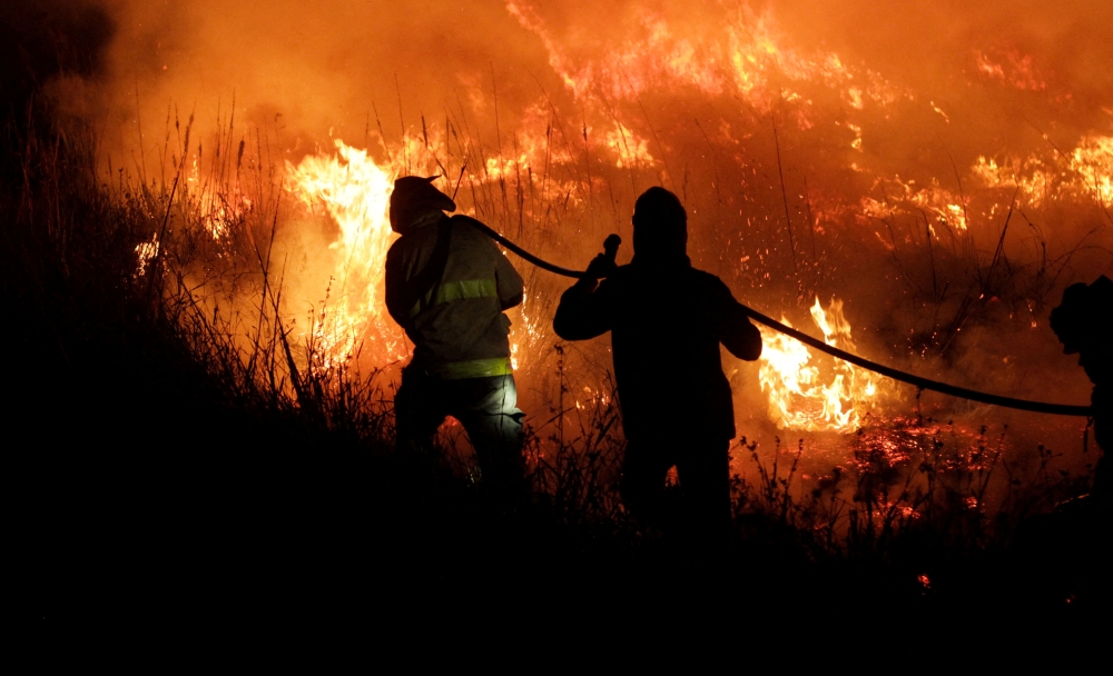 Firefighters battle a wildfire that has spread over more than 500,000 hectares in the northern province of Corrientes, in Portal San Antonio, Argentina, February 14, 2022.REUTERS/Sebastian Toba/File Photo