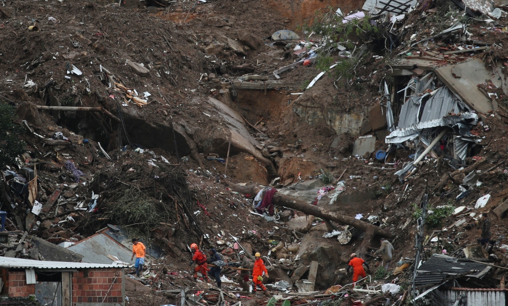 Rescue workers carry the body of a victim at the site of a mudslide at Morro da Oficina, following heavy rainfall in Petropolis, Brazil February 18, 2022. REUTERS/Ricardo Moraes