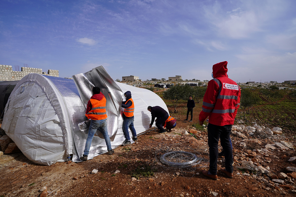 QRCS representatives setting up a tent for internally displaced people in Syria. 