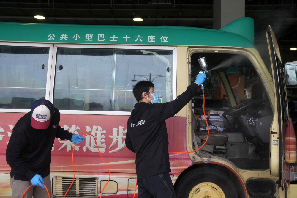 Cleaning staff spray disinfectant on a public minibus for driving coronavirus disease (COVID-19) patients, in Hong Kong, China February 21, 2022. REUTERS/Lam Yik/File Photo