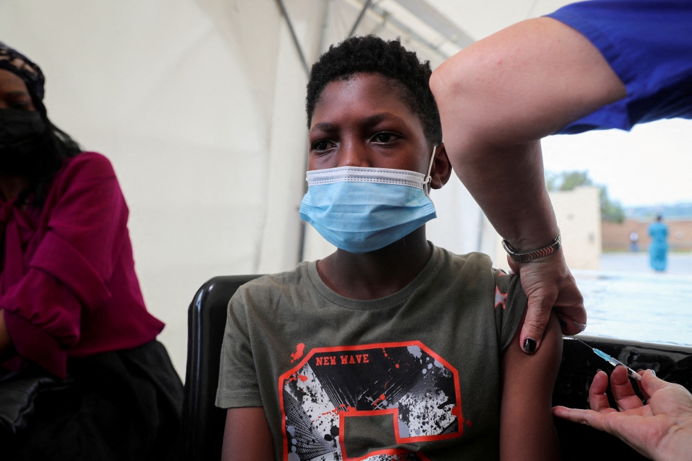 A healthcare worker administers the Pfizer coronavirus disease (COVID-19) vaccine to Simphiwe, 13, in Johannesburg, South Africa, December 04, 2021. REUTERS/Sumaya Hisham/File Photo