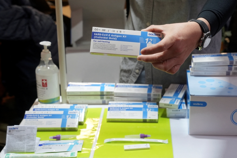 A promoter holds a box of rapid antigen test kit for the coronavirus disease (COVID-19) at a street stall in Hong Kong, China February 22, 2022. REUTERS/Lam Yik
