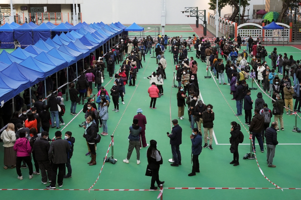 People wearing face masks line up at a testing centre for the coronavirus disease (COVID-19) in Hong Kong, China February 23, 2022. REUTERS/Lam Yik