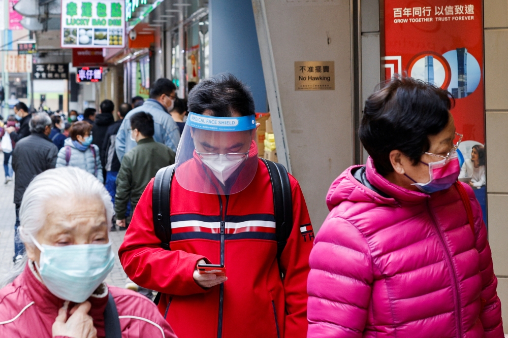 People are seen wearing face masks at the first day of a vaccine passport roll out, following the coronavirus disease (COVID-19) outbreak, in Hong Kong, China February 24, 2022. REUTERS/Tyrone Siu