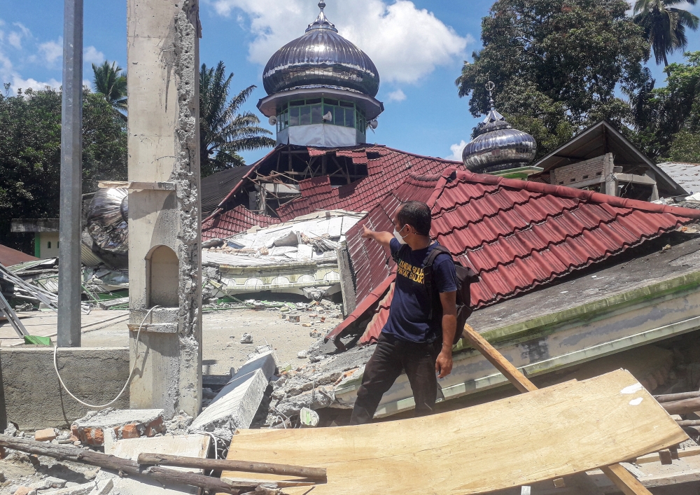 A man checks the damage of the destroyed Raya Kajai mosque after an earthquake in Kecamatan Talamau on Sumatra Island, Indonesia, February 25, 2022. Antara Foto/Altas Maulana via REUTERS