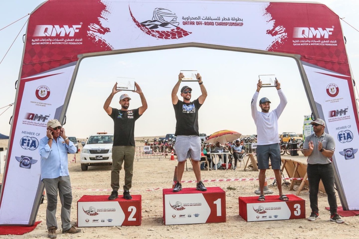 The podium winners of the 450CC motorcycles category celebrate during the presentation ceremony with Qatar Motor & Motorcycle Federation Executive Director Amro Al Hamad and other officials.