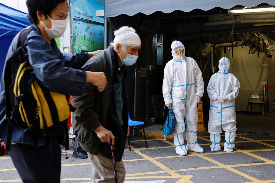 A patient and her relative wearing personal protective equipment (PPE) wait outside the Accident and Emergency (A&E) department, following the coronavirus disease (COVID-19) outbreak, in Hong Kong, China March 4, 2022. REUTERS/Tyrone Siu


