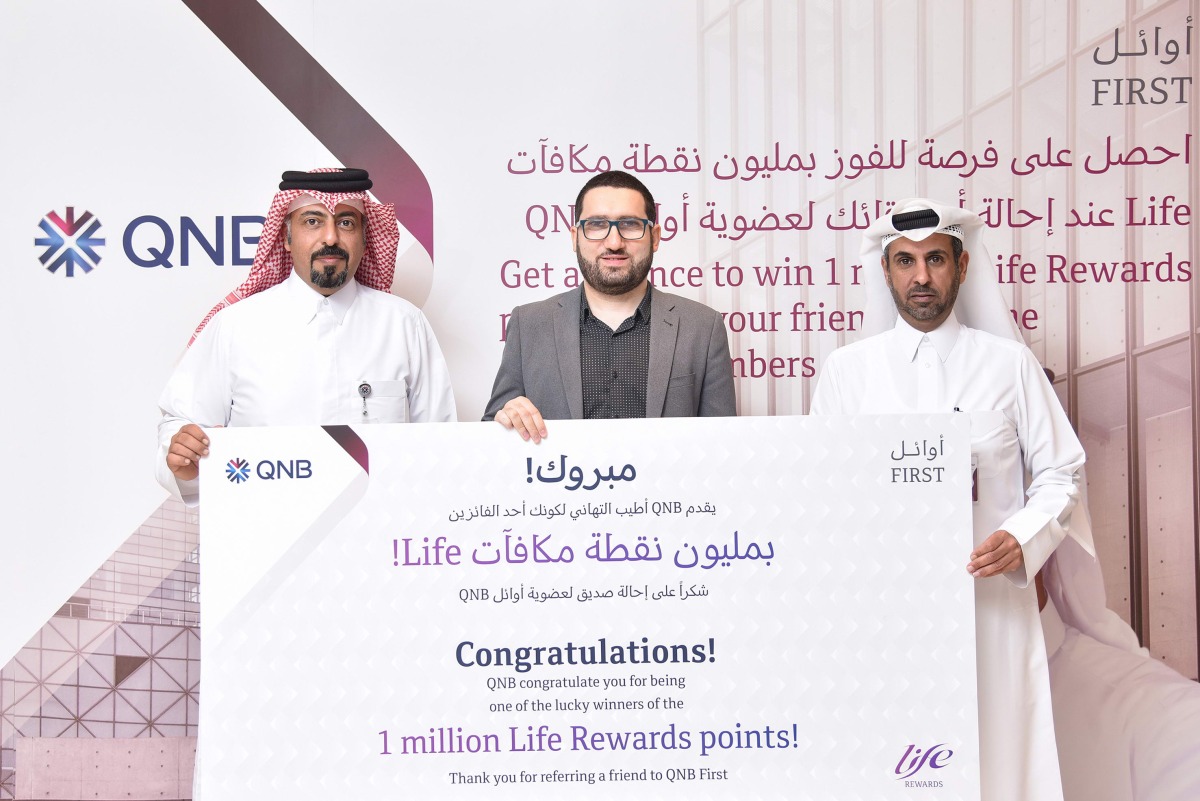 Adel Ali Al Malki, GM Group Retail at QNB awards the 1 million Life Rewards points to Moustafa Kamal Ibrahim, in the presence of a representative from the Ministry of Commerce and Industry. 