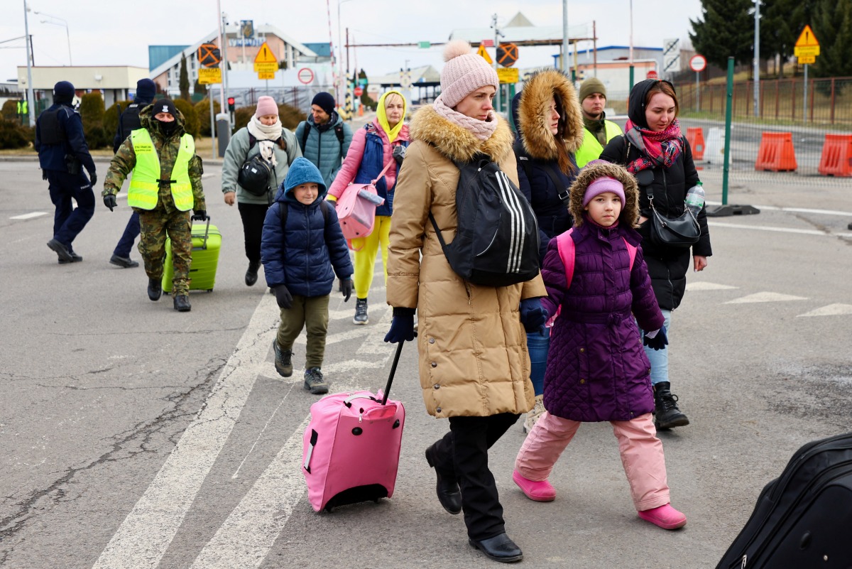 People cross the border from Ukraine to Poland, after fleeing Russia's invasion of Ukraine, in Korczowa, Poland, March 10, 2022. REUTERS/Fabrizio Bensch

