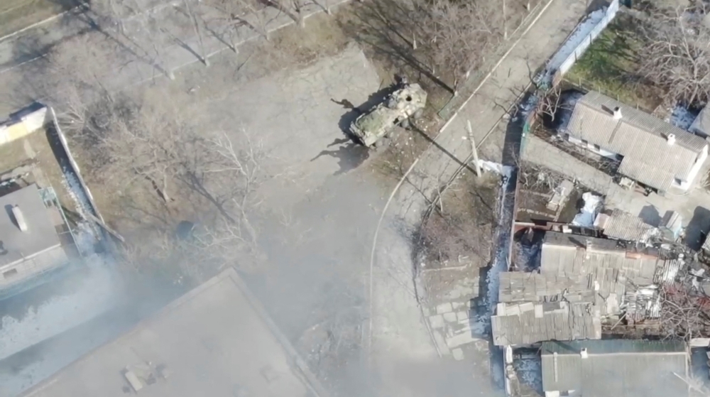 An aeriel view shows an armoured military vehicle next to a building, as Russia's invasion of Ukraine continues, in Mariupol, Ukraine as uploaded on March 13, 2022, in this handout drone video obtained by Reuters on March 13, 2022. Azov Mariupol/Handout via Reuters