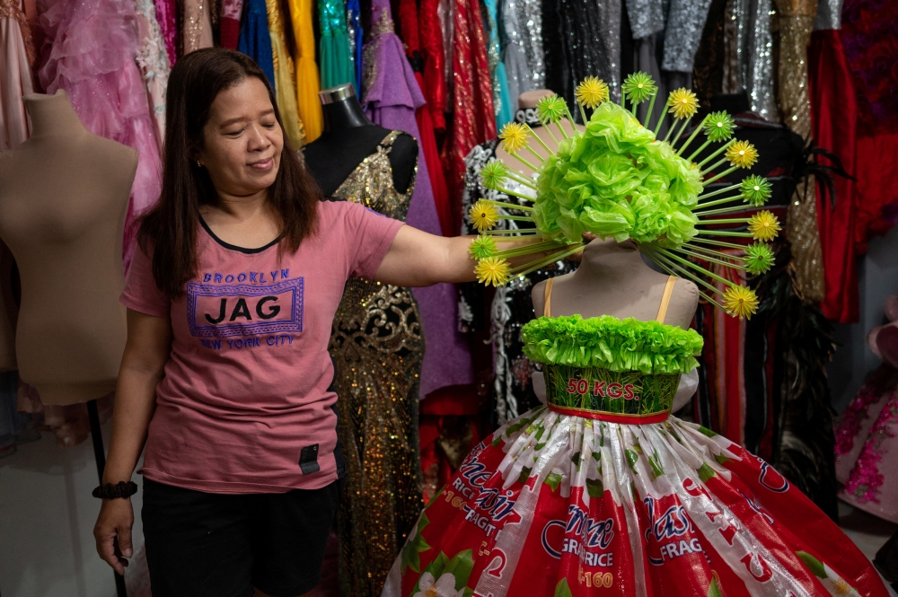 Nora Buenviaje shows an outfit made of recycled sacks of rice, plastic bags and straws, at her shop in Cainta, Rizal Province, Philippines, March 3, 2022. Picture taken March 3, 2022. REUTERS/Lisa Marie David
 