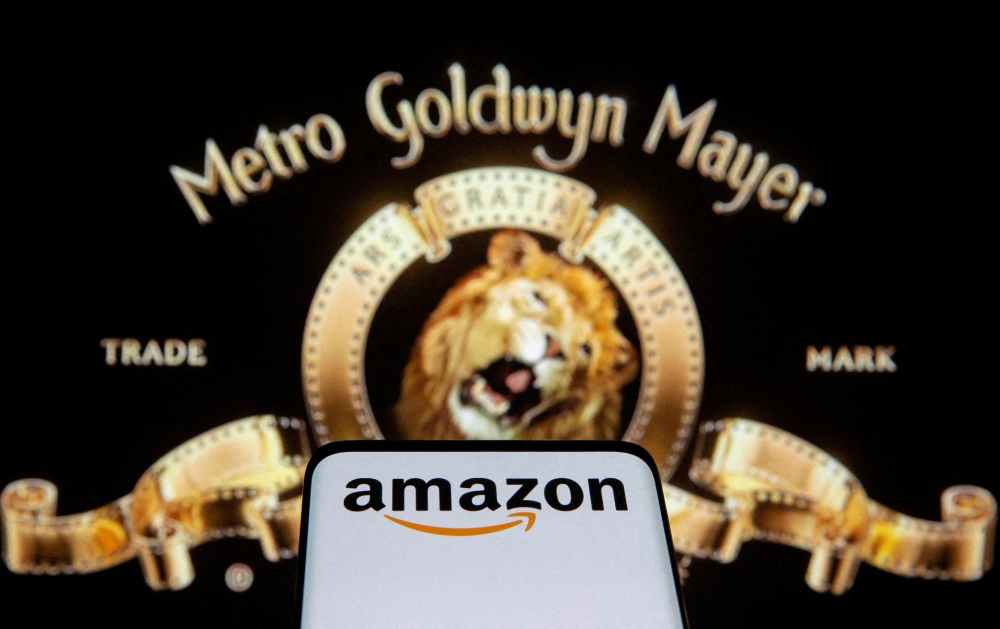 Smartphone with Amazon logo is seen in front of displayed MGM logo in this illustration taken, May 26, 2021. Reuters/Dado Ruvic/Illustration/File Photo