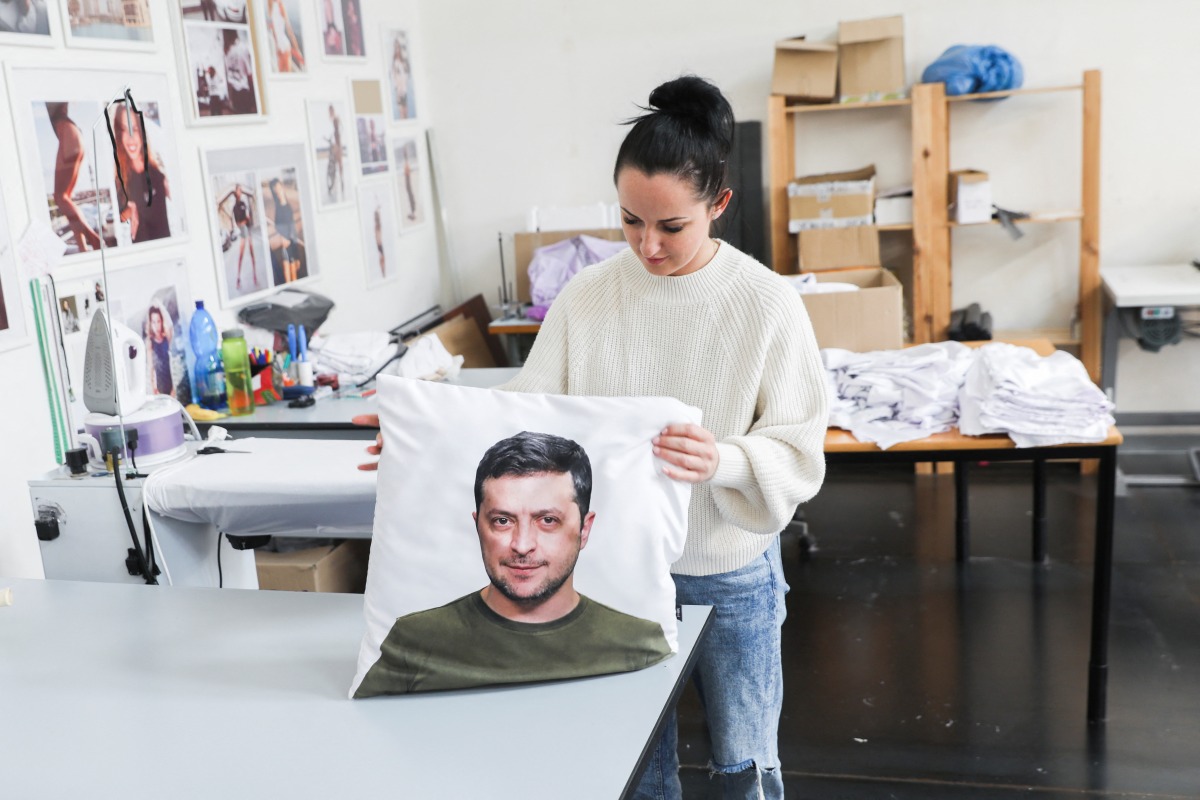 A woman holds a pillow cover with a portrait depicting Ukrainian President Volodymyr Zelenskiy, in Ceska Lipa, Czech Republic, March 17, 2022. Picture taken March 17, 2022. REUTERS/Eva Korinkova